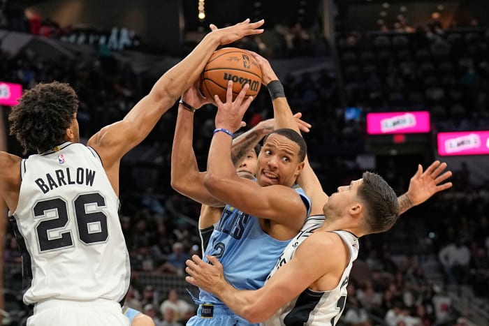 Memphis Grizzlies guard Desmond Bane (22) looks to pass the ball while defended by San Antonio Spurs forwards Dom Barlow (26) and Doug McDermott (17) during the second half at Frost Bank Center.